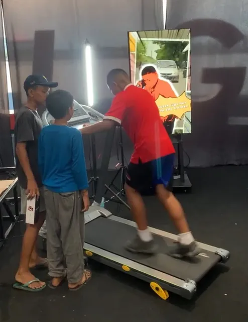 Pengunjung mencoba treadmill dalam instalasi Cabor Pansos.