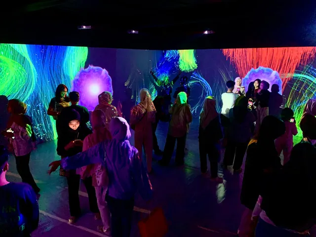 Suasana pengunjung di antara proyeksi warna-warni yang membungkus Immersive Room.