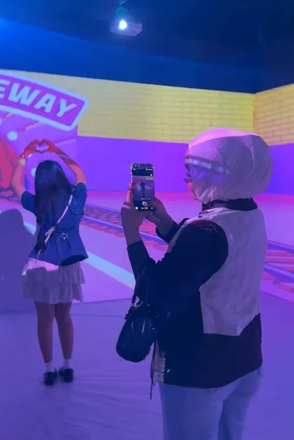 Pengunjung mengabadikan suasana Immersive Room melalui ponsel.